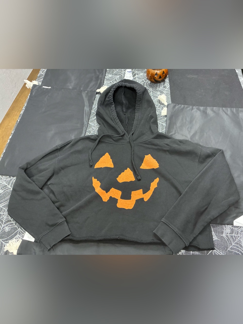 Black Craft Cropped Hoodie with Orange Jack-o'-Lantern Graphic